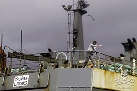 Masked officer on board Thunder throws chain at Sea Shepherd small boat crew. Photo: Simon Ager